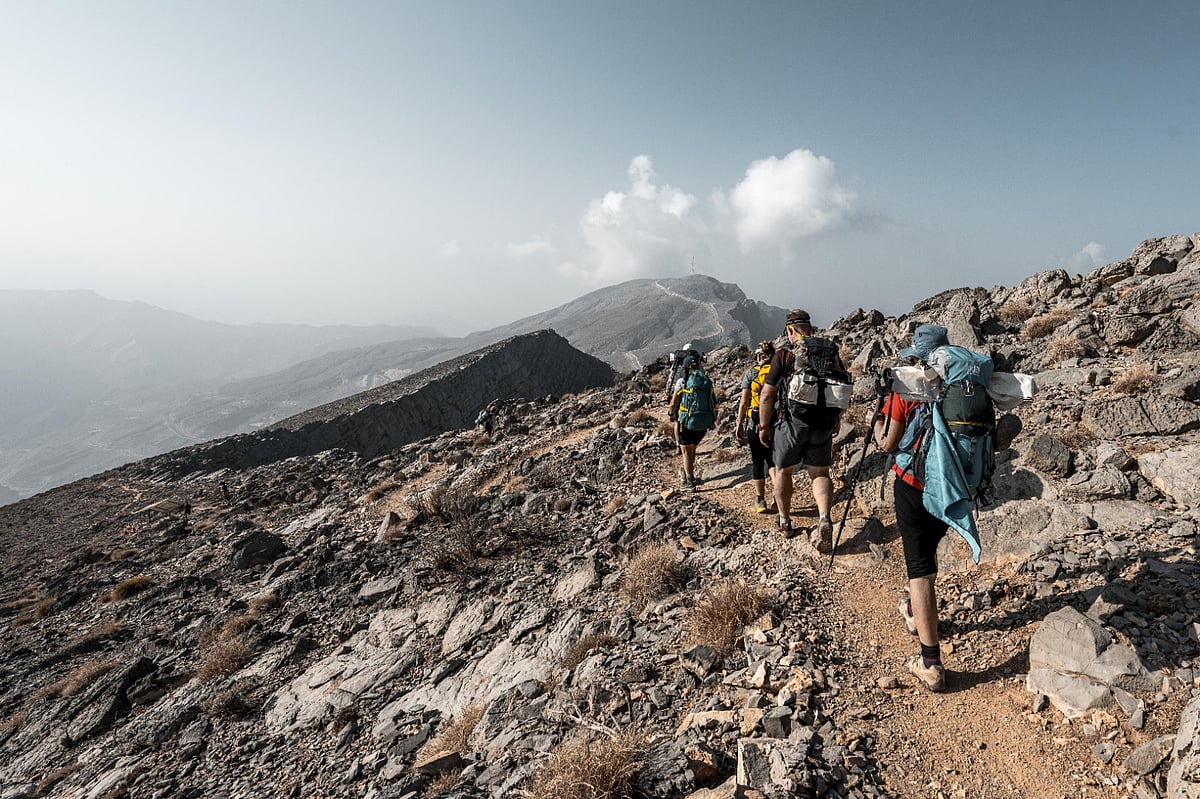 Hikers on a rocky trail on Jebel Jais