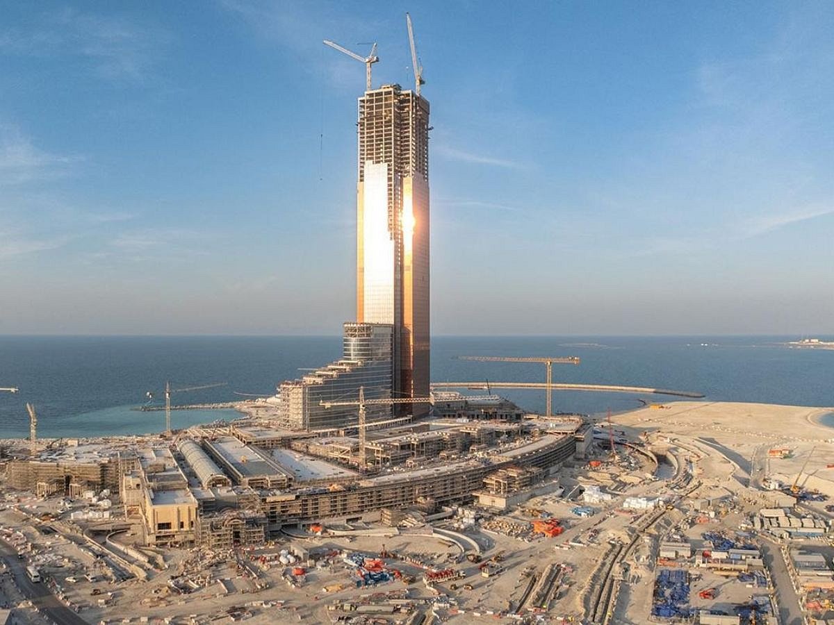 A high-rise tower under construction on Al Marjan Island at sunset